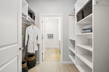 A hallway with a white door and a white coat hanging on the door.